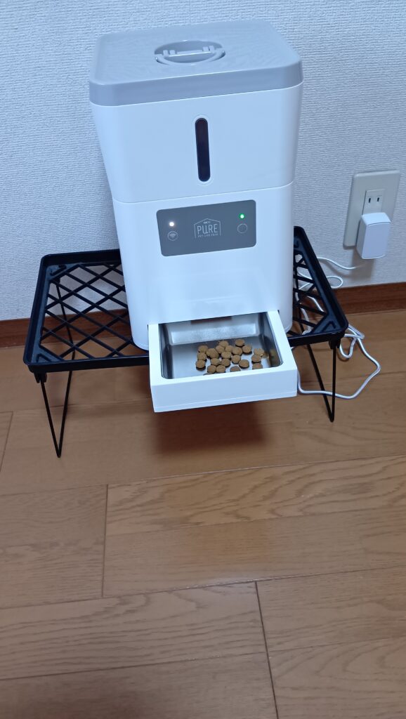自動給餌器からごはんが出るか試している写真